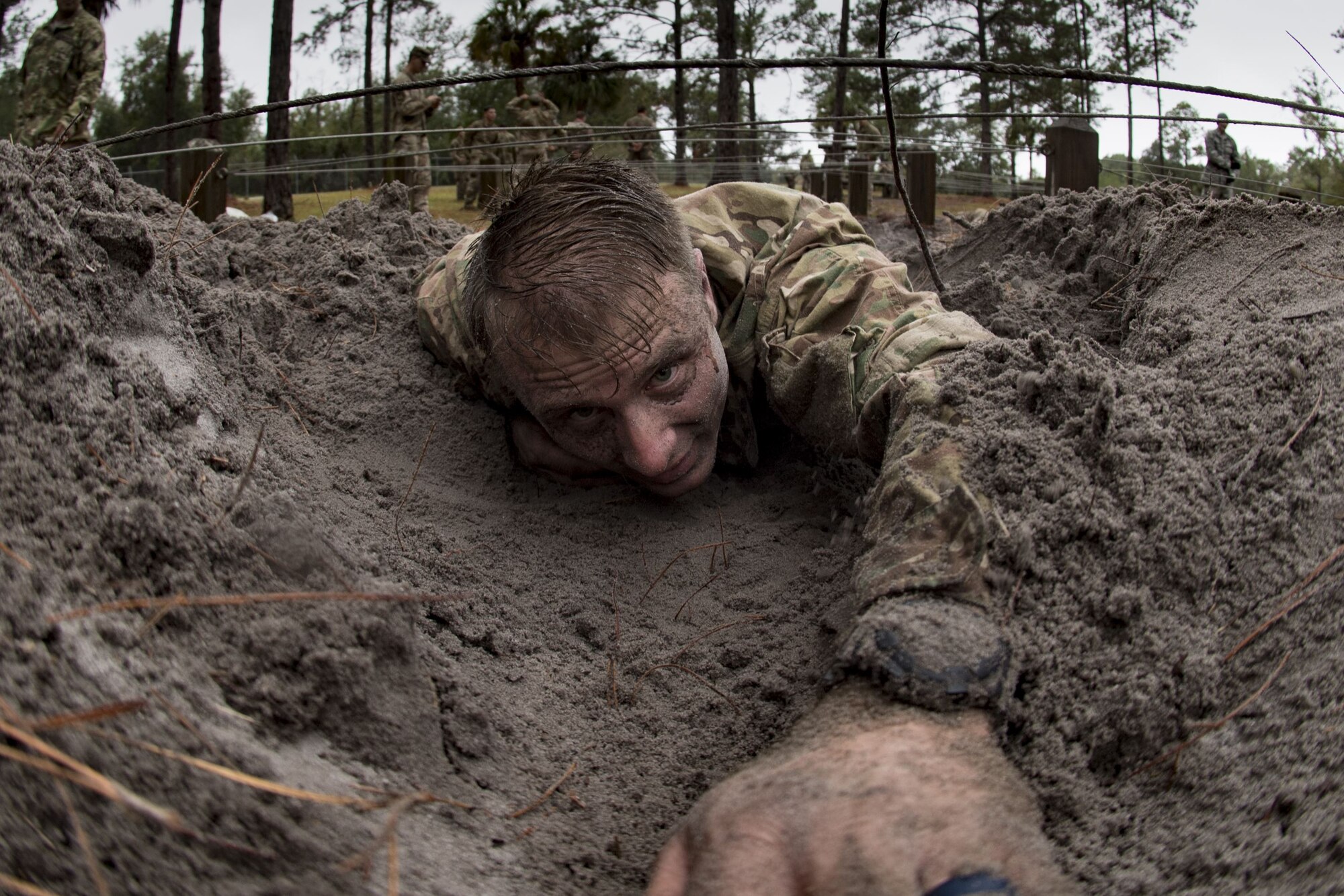 Airman 1st Class Brian Piperato, 824th Base Defense Squadron fireteam member, low crawls through an obstacle during an Army Air Assault readiness assessment, Dec. 7, 2017, at Camp Blanding, Fla. The AAA readiness assessment is designed to prepare Airmen for the Army Air Assault School curriculum as well as its physical and mental stressors. During AAA, U.S. troops are taught an array of skills associated with rotary-winged aircraft. These skills widen the 820th Base Defense Group’s ability to swiftly deploy and defend. (U.S. Air Force photo by Senior Airman Daniel Snider)