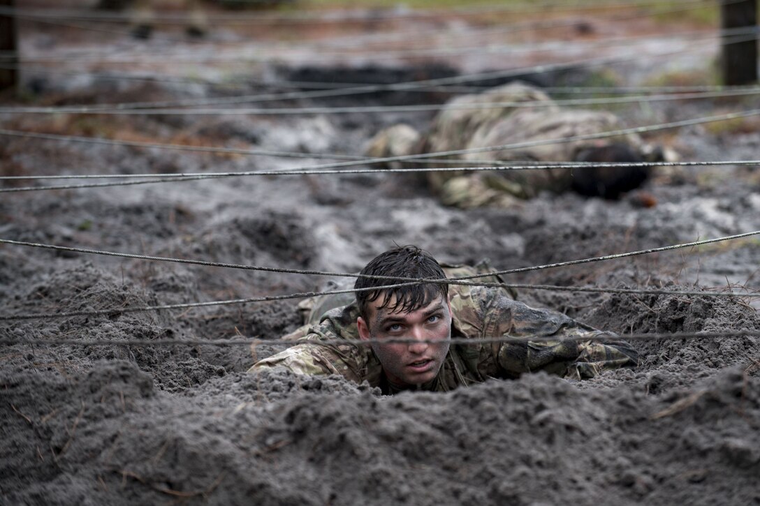 Airmen from the 820th Base Defense Group low crawl through an obstacle during an Army Air Assault readiness assessment, Dec. 7, 2017, at Camp Blanding, Fla. The AAA readiness assessment is designed to prepare Airmen for the Army Air Assault School curriculum as well as its physical and mental stressors. During AAA, U.S. troops are taught an array of skills associated with rotary-winged aircraft. These skills widen the 820th BDG’s ability to swiftly deploy and defend. (U.S. Air Force photo by Senior Airman Daniel Snider)