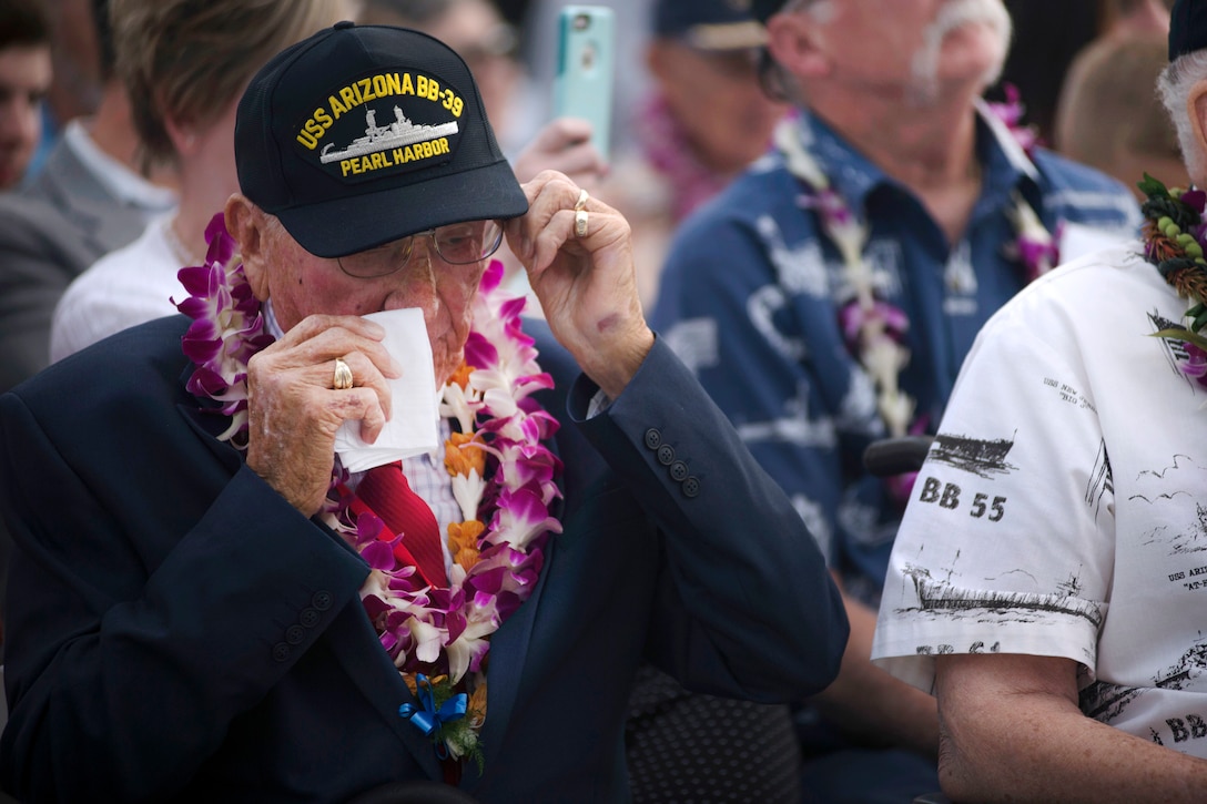 A veteran uses a handkerchief to wipe away tears.