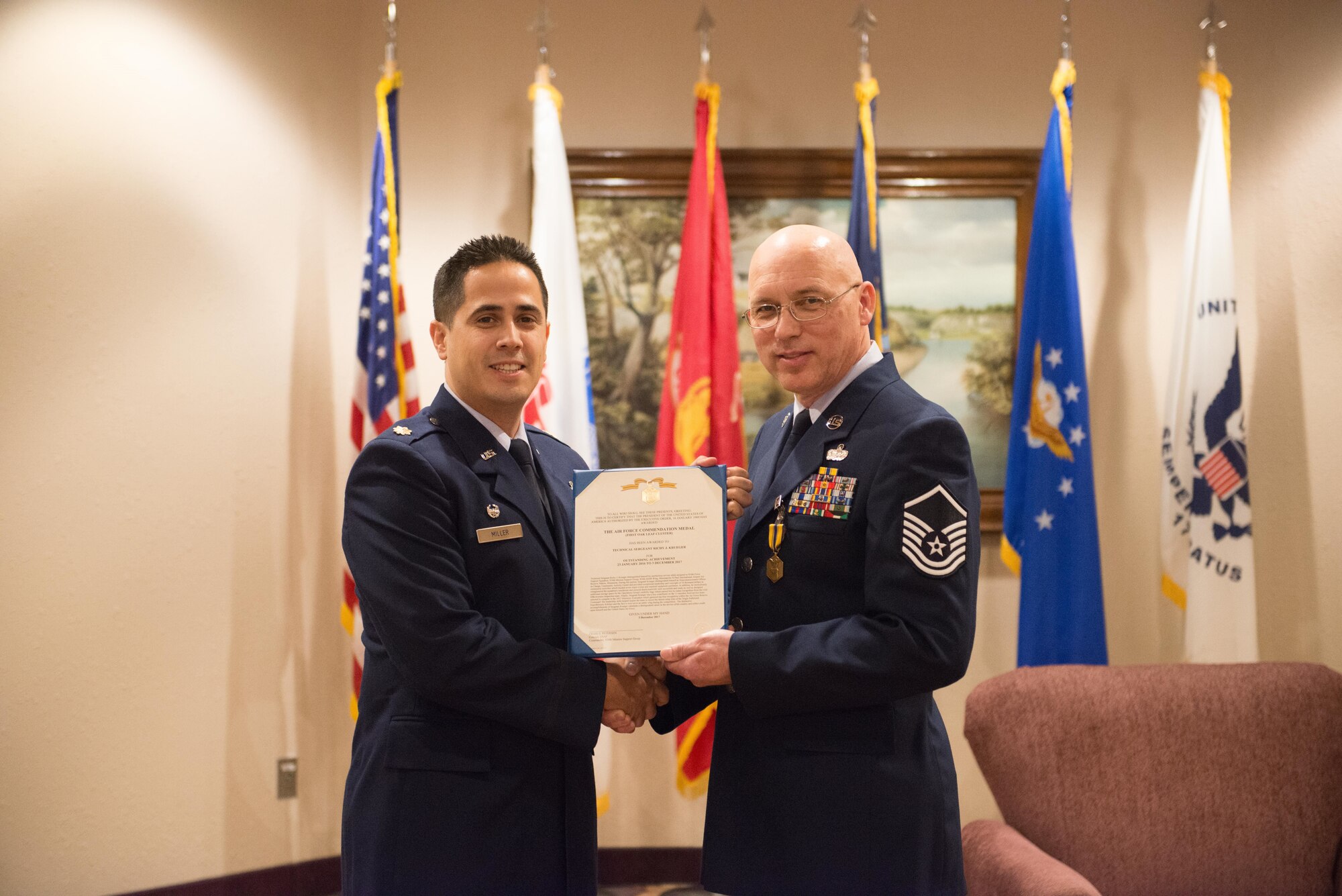 Master Sgt. Richy Krueger, right, receives his certificate of retirement from Major Miller on December 2. (U.S. Air Force photo by Tech. Sgt. Trevor Saylor)