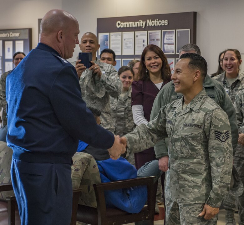 U.S. Air Force Gen. Jay Raymond, Air Force Space Command commander (left), congratulates U.S. Air Force Staff Sgt. Robert Valencia-Aiken (right) at Peterson Air Force Base, Colorado, Dec. 4, 2017. Raymond chose Valencia-Aiken to become an officer as a part of the Air Force's Senior Leader Enlisted Commissioning Program.  Valencia-Aiken is assigned to the 21st Medical Group at Peterson.  (U.S. Air Force photo by Dave Grim)