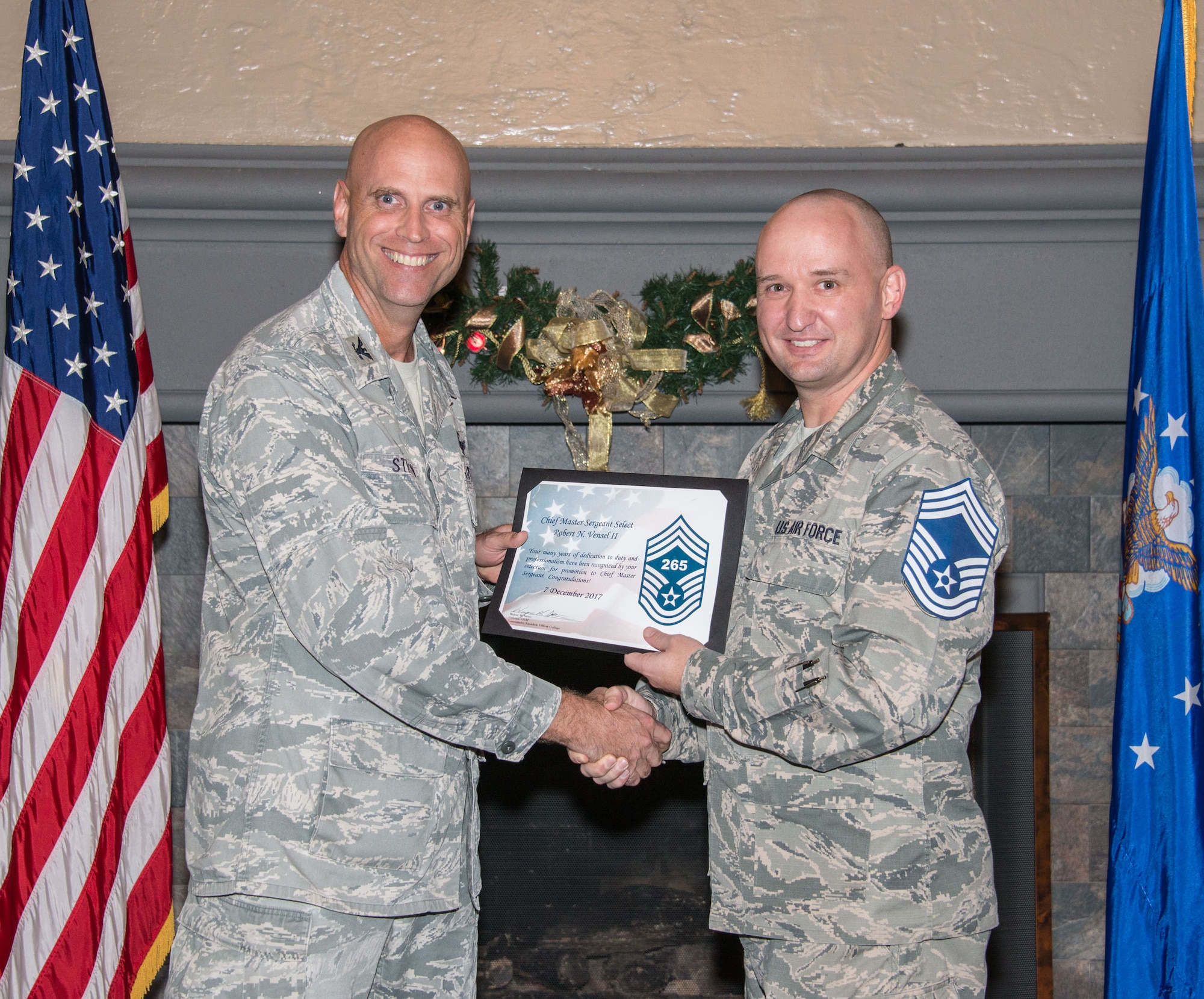 Col. Wayne Straw, Squadron Officer College commander, presents a certification of promotion to Chief Select Robert Vensel II, Air Force Reserve Officer Training superintendent, during the Maxwell Chief Select party, Dec. 7, 2017, Maxwell Air Force Base, Ala. Vensel was one of four senior master sergeants selected for the rank of chief master sergeant, the highest rank in the enlisted corps. (U.S. Air Force photo by Trey Ward)