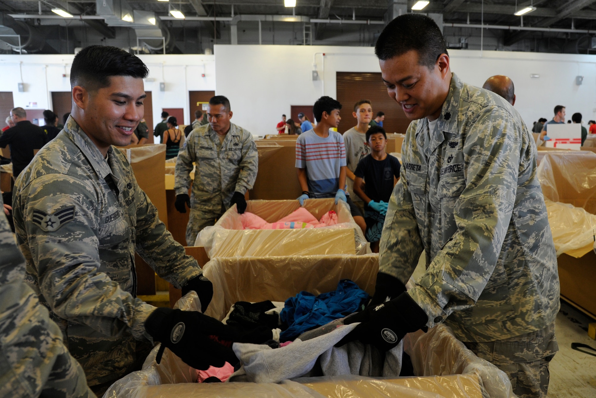Reserve Citizen Airmen Senior Airman Aleron Guerrero, of Mangilao, Guam, air transportation specialists from the 44th Aerial Port Squadron and Lt. Col. Melvin Ibaretta, 624th Regional Support Group deputy commander, help fill boxes full of critical supplies during Operation Christmas Drop Dec. 9, 2017, at Andersen Air Force Base, Guam. Operation Christmas Drop has been providing critical supplies to 56 Micronesian Islands since 1952. The 44th Aerial Port Squadron supports the 624th Regional Support Group’s mission of providing mission essential combat readiness, quality management and peacetime deployments in the Pacific area of responsibility. (U.S. Air Force photo by Staff Sgt. Daena Mansapit)