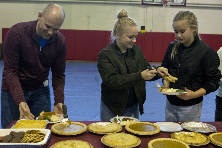 CAMP FOSTER, OKINAWA, Japan- A family serves each other pie at Headquarters and Support Battalion’s annual holiday party Dec. 5 at the Foster Fieldhouse aboard Camp Foster, Okinawa, Japan. Participants sat down to enjoy a home-cooked meal of holiday favorites like turkey, ham and mashed potatoes. The party brought Marines and their families out for a night of festive fun. (U.S. Marine Corps photo by Pvt. Nicole Rogge)