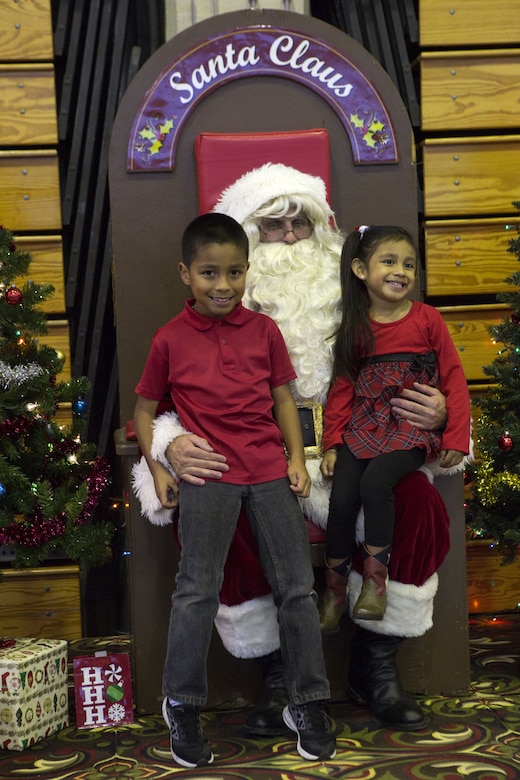 CAMP FOSTER, OKINAWA, Japan- Children take a photo with Santa at Headquarters and Support Battalion’s annual holiday party Dec. 5 at the Foster Fieldhouse aboard Camp Foster, Okinawa, Japan.