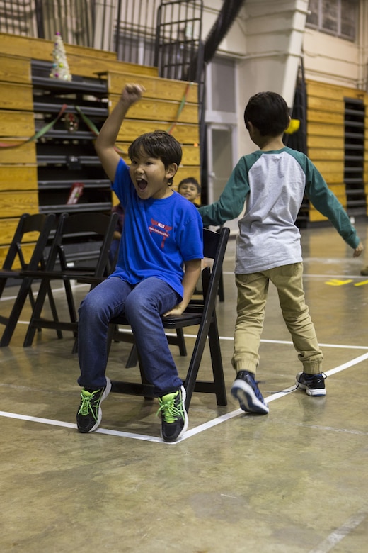 CAMP FOSTER, OKINAWA, Japan- A child wins a round of musical chairs at Headquarters and Support Battalion’s annual holiday party Dec. 5 at the Foster Fieldhouse aboard Camp Foster, Okinawa, Japan.