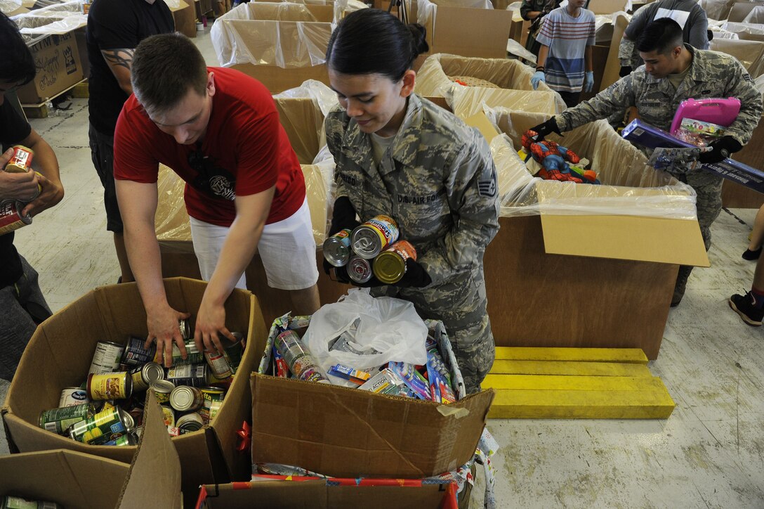 Reserve Citizen Airmen Staff Sgt. Kaija Garrido, of Sinajana, Guam, and Senior Airman Aleron Guerrero, of Mangilao, Guam, air transportation specialists from the 44th Aerial Port Squadron help fill boxes full of critical supplies during Operation Christmas Drop Dec. 9, 2017, at Andersen Air Force Base, Guam. Operation Christmas Drop has been providing critical supplies to 56 Micronesian Islands since 1952. The 44th Aerial Port Squadron supports the 624th Regional Support Group’s mission of providing mission essential combat readiness, quality management and peacetime deployments in the Pacific area of responsibility. (U.S. Air Force photo by Staff Sgt. Daena Mansapit)