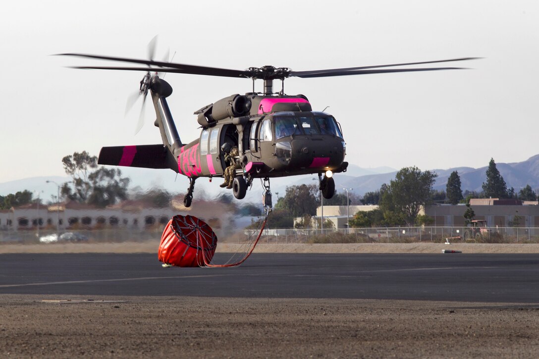 A UH-60 Black Hawk helicopter lands to refuel.