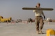Staff Sgt. Joshua Swertfager, a native of Fresno, Calif., assigned to the 332nd Expeditionary Civil Engineer Squadron carries a large squeegee to another location after smoothing out a new concrete slab on the runway of an undisclosed location in Southwest Asia Nov. 28, 2017. Swertfager, a heavy equipment operator worked with other squadron members to repair a runway due to wear and tear of constant use by U.S. and Coalition forces flying sorties against ISIS. (U.S. Air Force photo by Senior Master Sgt. Cohen A. Young)