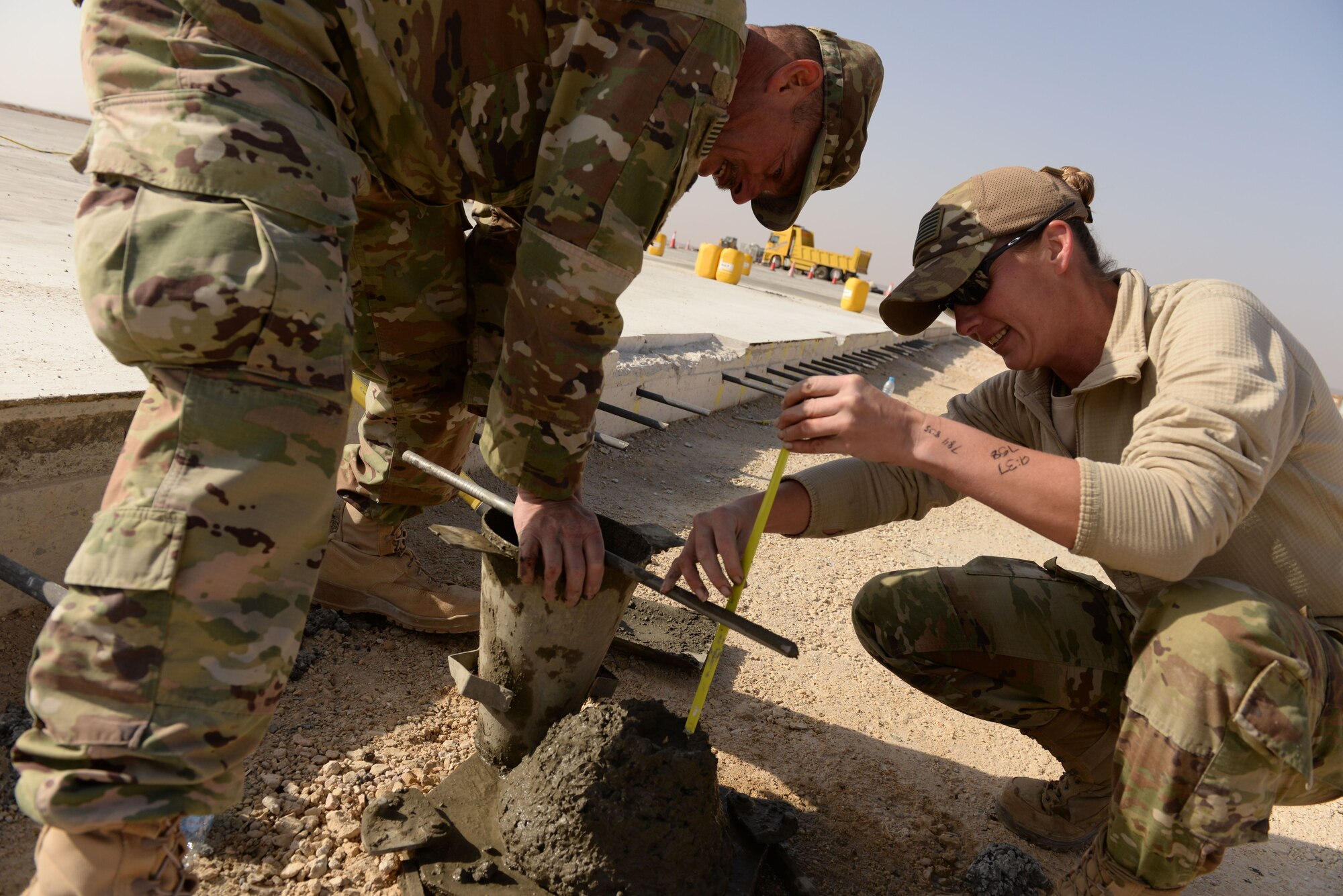 Staff Sgt. Joseph Buch and Tech Sgt. Erin Eagleson, North Dakota Air National Guardsmen assigned to the 332nd Expeditionary Civil Engineer Squadron take a slump measurement while testing a fresh batch of concrete before her team pours a new slab of concrete at an undisclosed location in Southwest Asia Nov. 28, 2017. The sample is checked for fluidity and strength on the seventh and 28th day to ensure a proper product has been provided. (U.S. Air Force photo by Senior Master Sgt. Cohen A. Young)