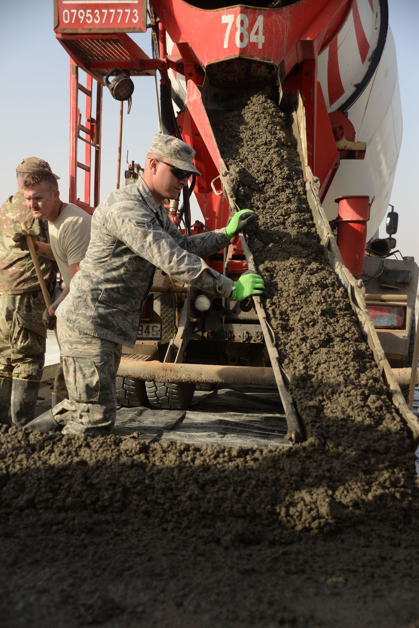 Airman 1st Class Jerre Myrick, a heavy equipment operator, guides wet concrete into a slab as he and other members assigned to the 332nd Expeditionary Civil Engineer Squadron repair a damaged runway at an undisclosed location in Southwest Asia Nov. 28, 2017. The team is in the process of repairing more than 60 dilapidated slabs, and 425 spalls. (U.S. Air Force photo by Senior Master Sgt. Cohen A. Young)