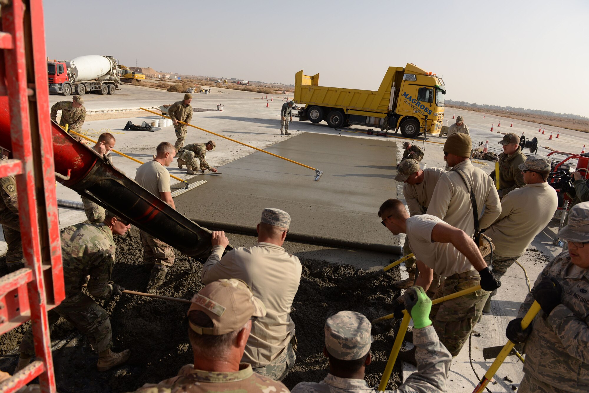 Air Force members assigned to the 332nd Civil Engineer Squadron work quickly to repair a slab on the runaway at an undisclosed location in Southwest Asia Nov. 28, 2017. The fast pace is necessary because of the wind and the dry weather, which inhibits the drying process. (U.S. Air Force photo by Senior Master Sgt. Cohen A. Young)