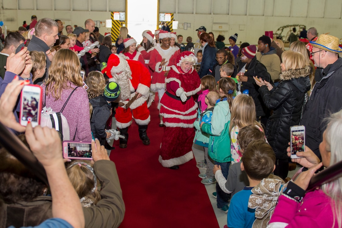 Mr. and Mrs. Santa Claus greet Parents and Children Fighting Cancer holiday party attendees in Hangar 3 on Joint Base Andrews, Md., Dec. 9, 2017. The special guests also visited children who were unable to attend the event at Walter Reed National Military Medical Center. This year marked the 30th anniversary of the JBA Fisher House event.