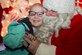 Erin Roseberry, Parents and Children Fighting Cancer holiday party attendee, smiles while sitting on Mr. Santa Claus’ lap on Joint Base Andrews, Md., Dec. 9, 2017. Mr. and Mrs. Claus presented children and families with gifts during the 30th annual celebration.