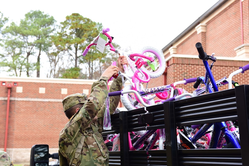 U.S. Army Private Ryan Youse, 128th Aviation Brigade Advanced Individual Training student, loads a bicycle onto a truck in support of the U.S. Marine Corps’ Toys for Tots program at Joint Base Langley-Eustis, Va., Dec. 6, 2017.