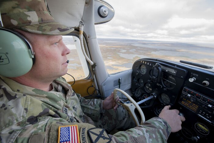 A service member flies an airplane.