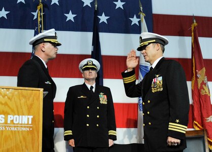 U.S. Navy Commander Carl Brobst, left, assumes command of the Naval Consolidated Brig Charleston with a salute from his predecessor, Cmdr. Brett Pugsley, right, while Lt. Cmdr Christopher Adams, U.S. Navy Chaplain Corps, observes during a change of command ceremony Dec. 8, 2017, onboard the USS Yorktown, Mount Pleasant, S.C.