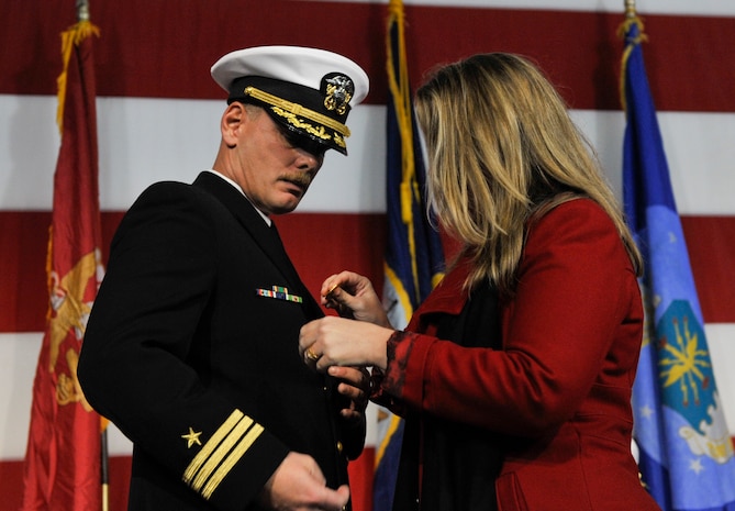 Nicki Brobst pins the command pin on her husband, U.S. Navy Cmdr. Carl Brobst, during the Naval Consolidated Brig Charleston change of command ceremony Dec. 8, 2017, onboard the USS Yorktown in Mt. Pleasant, S.C.