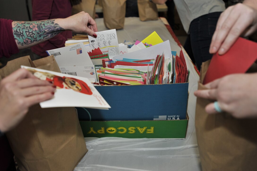 Volunteers of the annual Shower Shaw with Cookies cookie drive put holiday cards into bags of cookies prepared for dorm Airmen at Shaw Air Force Base, S.C., Dec. 7, 2017.