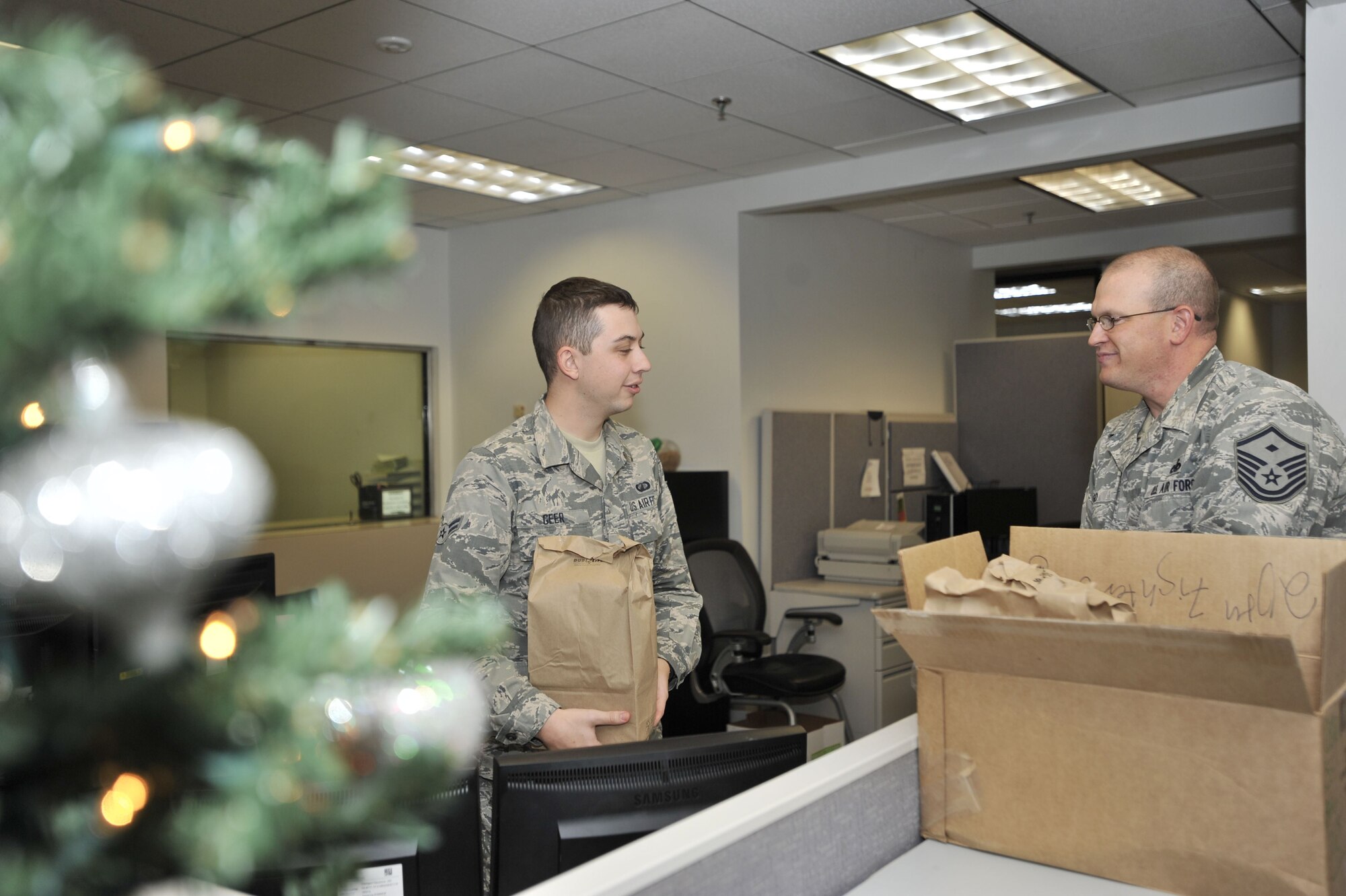 U.S. Air Force Airman 1st Class Nathan Greer, 20th Comptroller Squadron (CPTS) customer service representative, left, receives holiday cookies from Master Sgt. Raymond Lego, 20th CPTS first sergeant, at Shaw Air Force Base, S.C., Dec. 7, 2017.