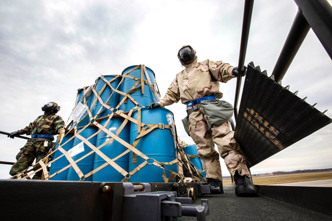 Airmen wearing mission oriented protective posture level two gear ensure cargo loads smoothly.