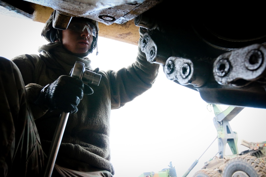 A soldiers conducts tank maintenance.