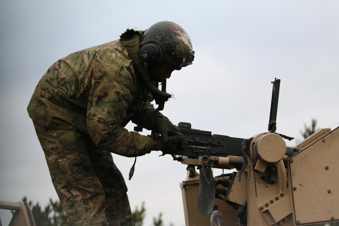 A soldiers does a machine gun check