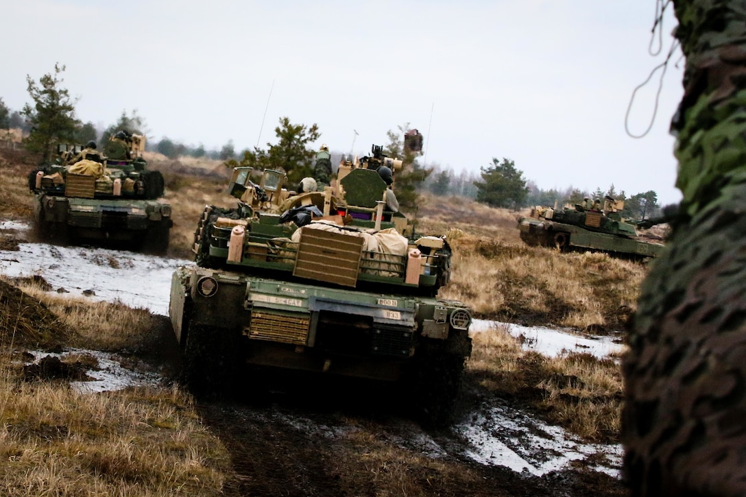 Tanks move into firing position during training.