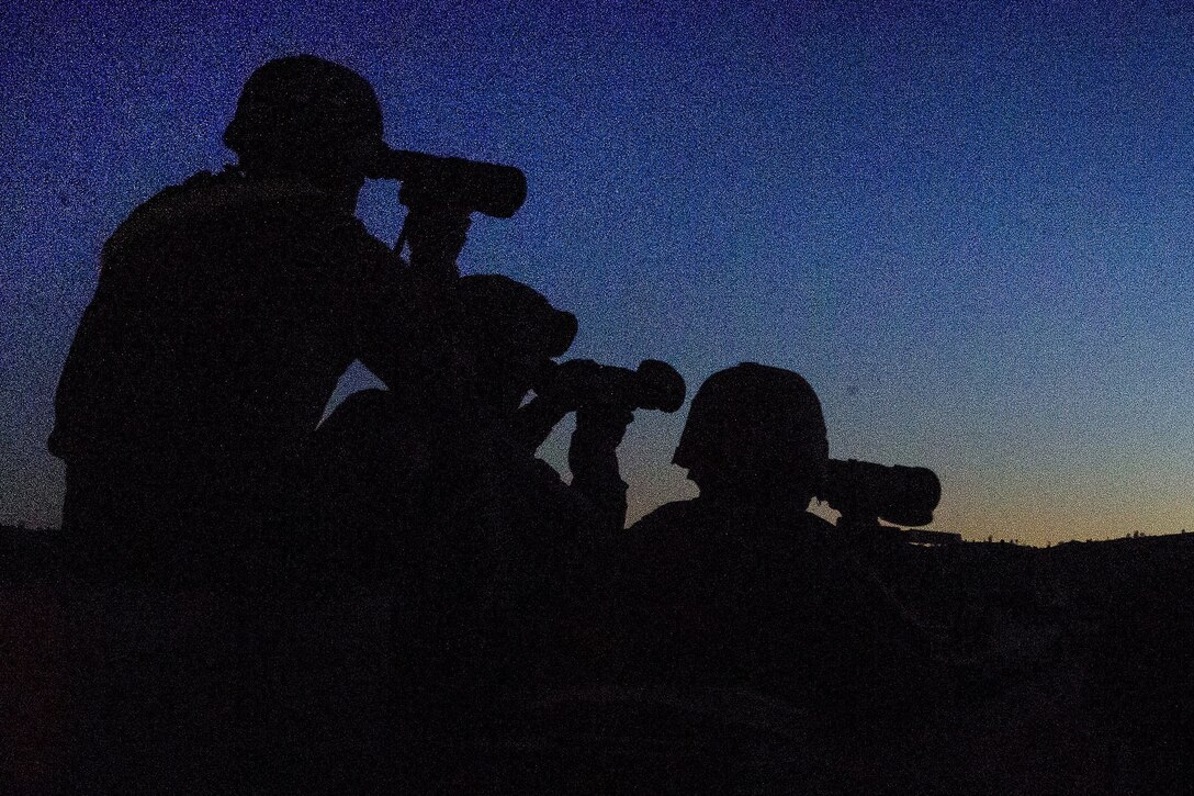 Soldiers and range cadre identify targets before participating in night live-fire qualification.