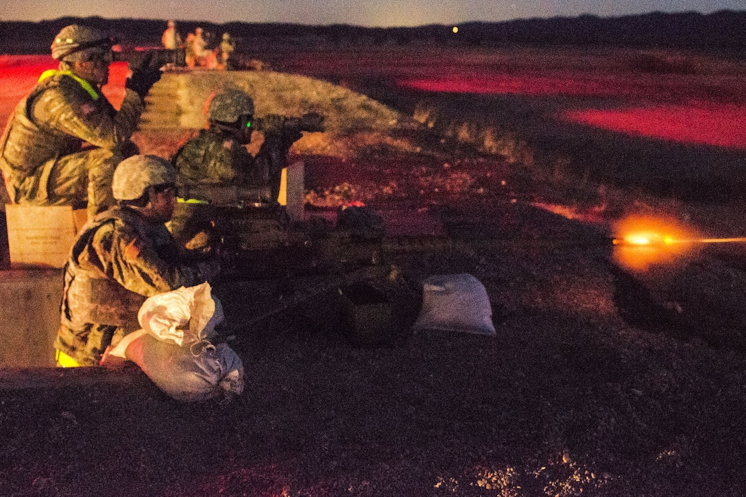 Soldiers conduct a night live-fire qualification with an M2 machine gun.