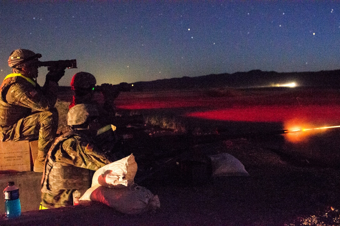 Soldiers conduct a night live-fire qualification with an M2 machine gun.