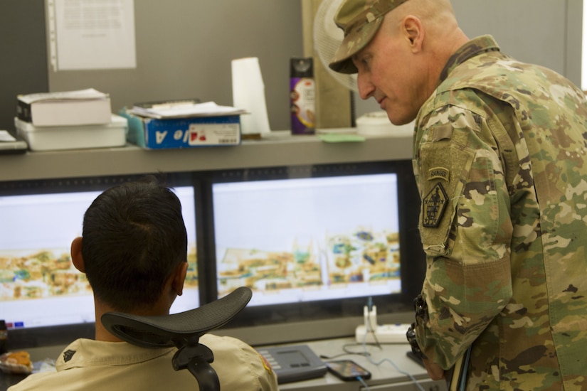 Two soldiers looking at computer screen.