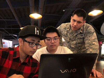 Maj. Barret Darnell, 315th Cyber Operations Squadron, assists local high school students with some “Hacking 101” challenges