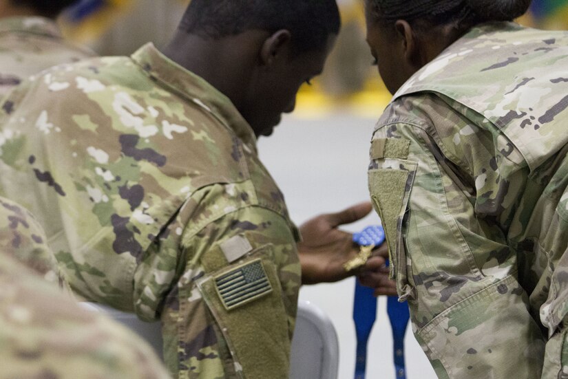 Two Soldiers admiring a medal.