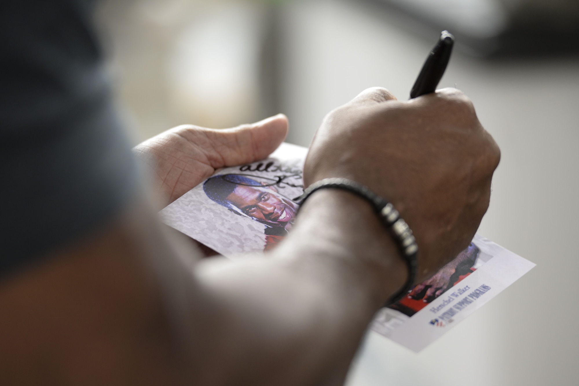 Professional athlete, Herschel Walker, signs an autograph Dec. 5, 2017, while he visits with Airmen at the 436th Aerial Port Squadron on Dover Air Force Base, Del. Walker was diagnosed with Dissociative Identity Disorder in 1999, but he learned how to move forward as an entrepreneur and motivational speaker. (U.S. Air Force photo by Staff Sgt. Aaron J. Jenne)