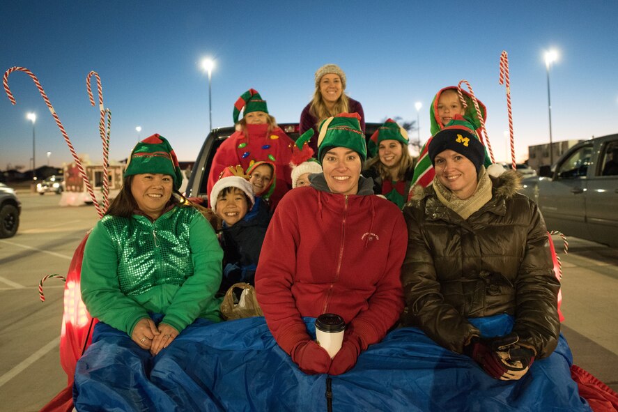 Members of Cannon Air Force Base, New Mexico, pose for a photo during the holiday parade and tree lighting ceremony Dec. 7, 2017. Col. Michael Conley, 27th Special Operations Wing vice commander, handed out awards for best light display, most spirited float and best overall float. (U.S. Air Force photo by Staff Sgt. Michael Washburn/Released)