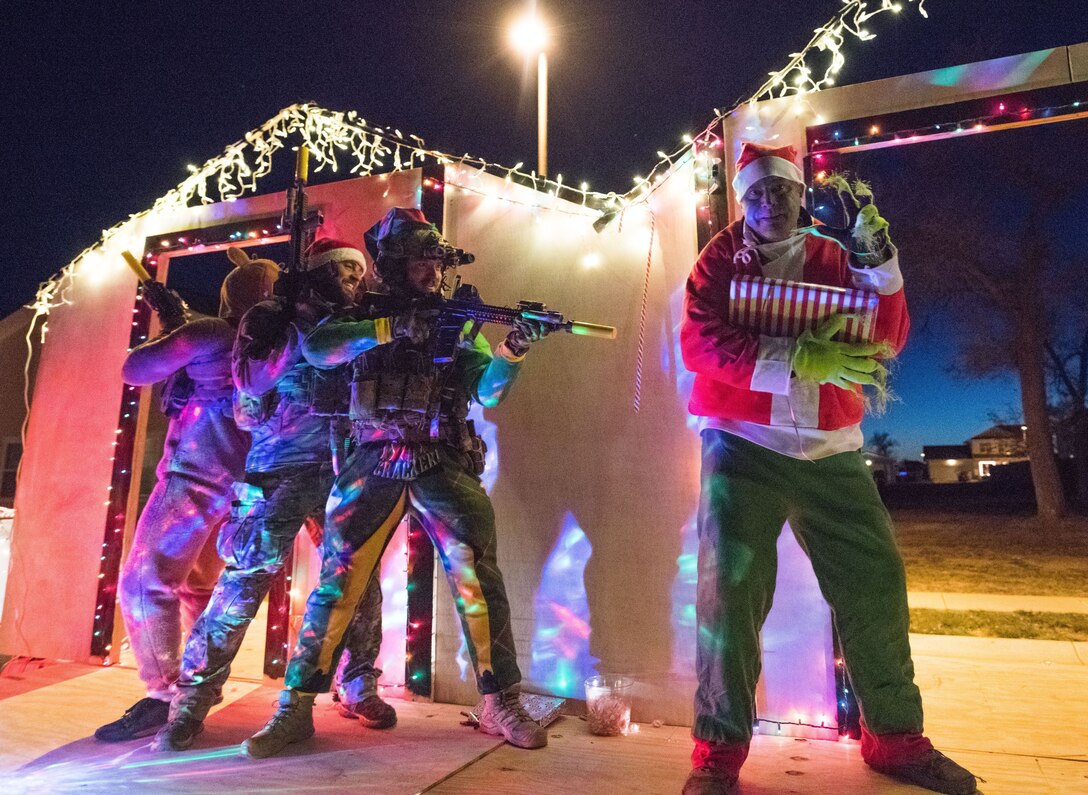 Special operations Airmen chase the Grinch around their float during the holiday parade and tree lighting ceremony Dec. 7, 2017, at Cannon Air Force Base, New Mexico. The floats were made by various squadrons on base. (U.S. Air Force photo by Staff Sgt. Michael Washburn/Released)