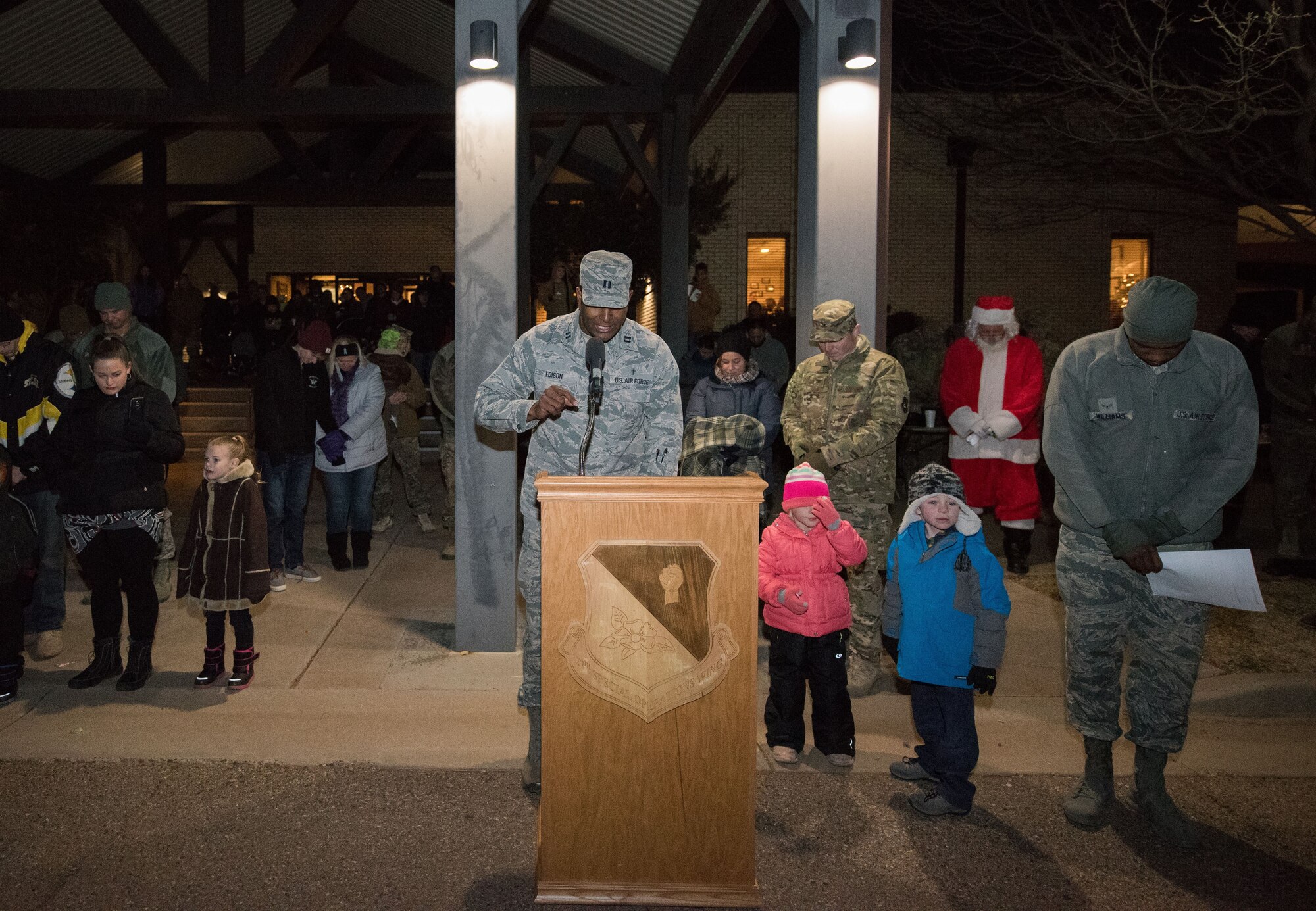 Chaplain (Capt.) Karlton Edison, 27th Special Operations Wing Chaplain, delivers an invocation during the holiday parade and tree lighting ceremony Dec. 7, 2017, at Cannon Air Force Base, New Mexico. Col. Michael Conley, 27th Special Operations Wing vice commander, handed out awards for best light display, most spirited float and best overall float. (U.S. Air Force photo by Staff Sgt. Michael Washburn/Released)