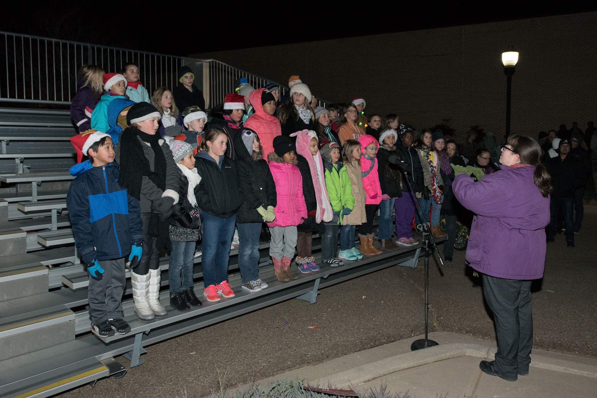 Children with the Barry Elementary School perform Christmas carols during the holiday parade and tree lighting ceremony Dec. 7, 2017, at Cannon Air Force Base, New Mexico. The parade included floats decorated by the squadrons and an appearance by Santa Claus himself. (U.S. Air Force photo by Staff Sgt. Michael Washburn/Released)