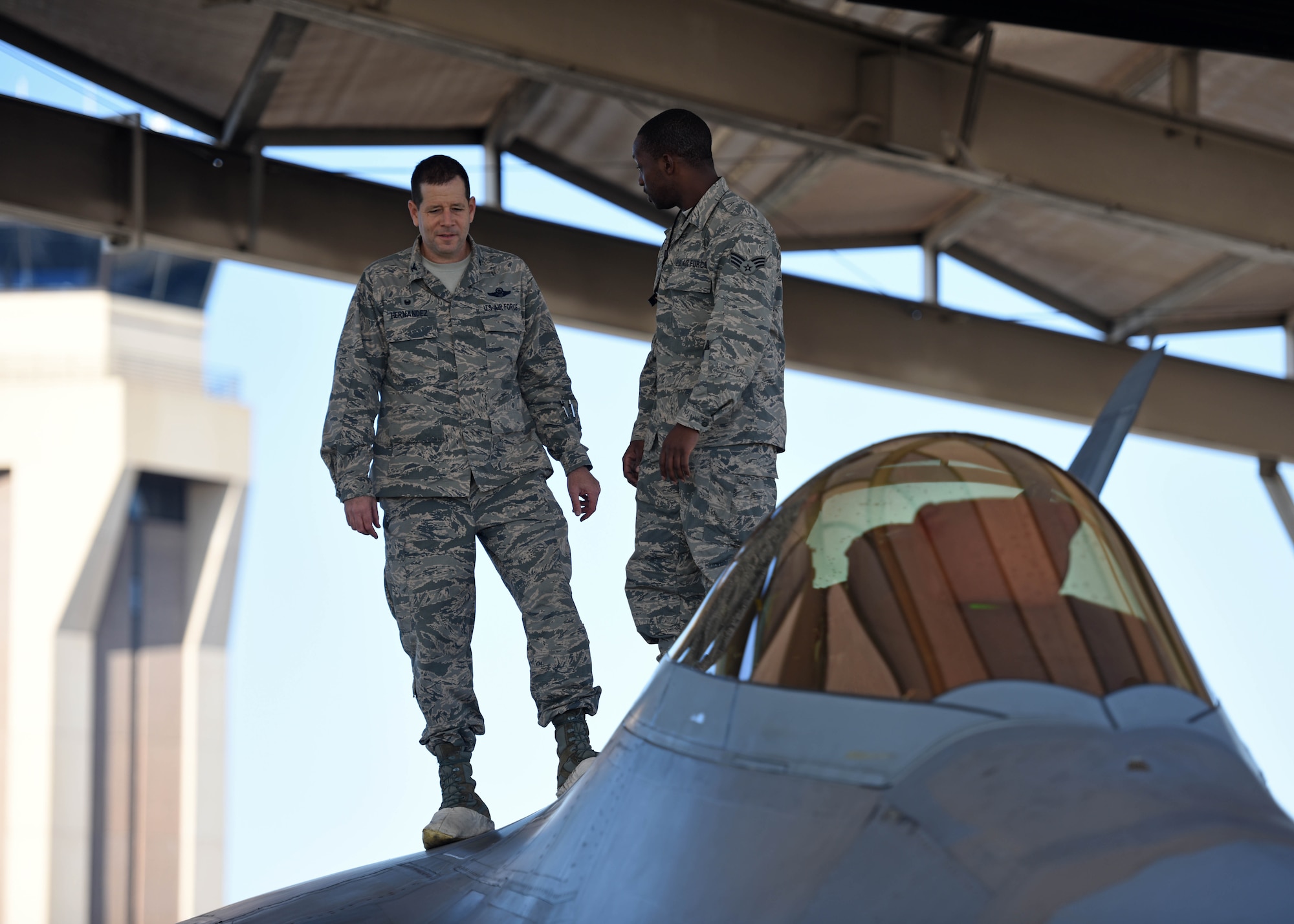 U.S. Air Force Senior Airman Gerald Austin (right), 44th Fighter Group, 44th Maintenance Squadron aircraft maintenance journeyman, stands atop an F-22 Raptor with Col. Michael Hernandez, 325th Fighter Wing commander, while participating in the Airman Shadow Program at Tyndall Air Force Base, Fla., Nov. 3, 2017. Austin was chosen by his leadership to showcase his duties as an F-22 Raptor crew chief to the commander. (U.S. Air Force photo by Airman 1st Class Isaiah J. Soliz/Released)