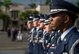 Honor Guard Airmen stand in a line outside the 15th Wing headquarters building.
