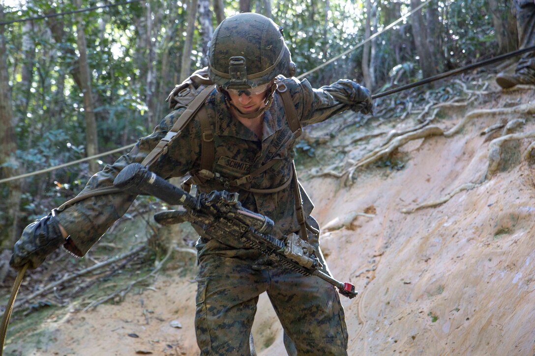 A Marine overcomes a hasty rappel obstacle during the 3rd Marine Division Annual Squad Competition.