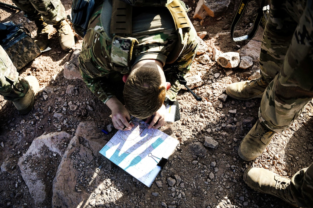 A U.S. soldier plots grid coordinates for a live-fire mission during training.