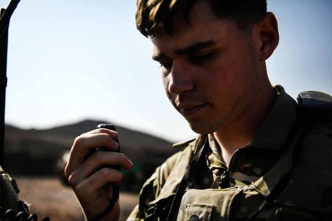 A U.S. soldier uses a radio to call his headquarters leadership team for French support to suppress a target during training.