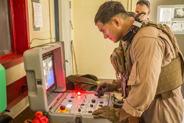 Sergeant Stephen Gomez uses the Remote Fuse Disassembly System to safely examine a fuse aboard Marine Corps Air Station Beaufort, July 25. Explosive Ordnance Disposal Marines conducted the training as part of their quarterly training. Gomez is an Explosive Ordnance Disposal Marine with EOD, MCAS Beaufort.