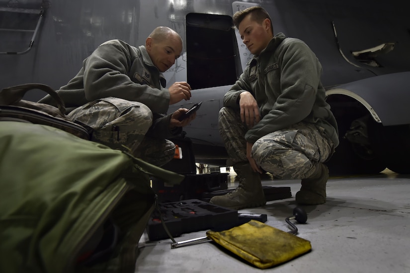 Tech Sgt. Brian Duell, left, 437th Aircraft Maintenance Squadron aerospace maintenance craftsman, and Airman 1st Class Nicolas Rainey, right, 437th AMXS aerospace maintenance technician, perform ground maintenance on a C-17 Globemaster III in preparation for a Joint Forcible Entry training event in support of the U.S. Air Force Weapons School Integration phase Dec. 8. Thirty seven C-17s, 21 C-130 Hercules and 120 U.S. Army paratroopers participated in the mobility portion of the WSINT phase during a simulated mass JFE event over a contested target Dec. 9, on a range near Nellis Air Force Base, Nev. The event demonstrates the U.S. Air Force’s ability to execute rapid, decisive responses to crises worldwide.