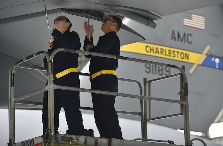 Staff Sgt. Erin Winkler, left, and Tech Sgt. Chris Kalif , right, both 437th Aircraft Maintenance Squadron aerospace maintenance craftsmen, perform ground maintenance on a C-17 Globemaster in preparation for a Joint Forcible Entry training event in support of the U.S. Air Force Weapons School Integration phase Dec. 8. Thirty seven C-17s, 21 C-130 Hercules and 120 U.S. Army paratroopers participated in the mobility portion of the WSINT phase during a simulated mass JFE event over a contested target Dec. 9, on a range near Nellis Air Force Base, Nev. The event demonstrates the U.S. Air Force’s ability to execute rapid, decisive responses to crises worldwide.
