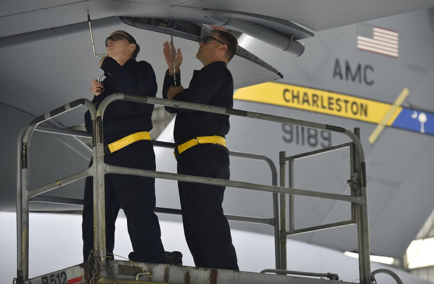 Staff Sgt. Erin Winkler, left, and Tech Sgt. Chris Kalif , right, both 437th Aircraft Maintenance Squadron aerospace maintenance craftsmen, perform ground maintenance on a C-17 Globemaster in preparation for a Joint Forcible Entry training event in support of the U.S. Air Force Weapons School Integration phase Dec. 8. Thirty seven C-17s, 21 C-130 Hercules and 120 U.S. Army paratroopers participated in the mobility portion of the WSINT phase during a simulated mass JFE event over a contested target Dec. 9, on a range near Nellis Air Force Base, Nev. The event demonstrates the U.S. Air Force’s ability to execute rapid, decisive responses to crises worldwide.