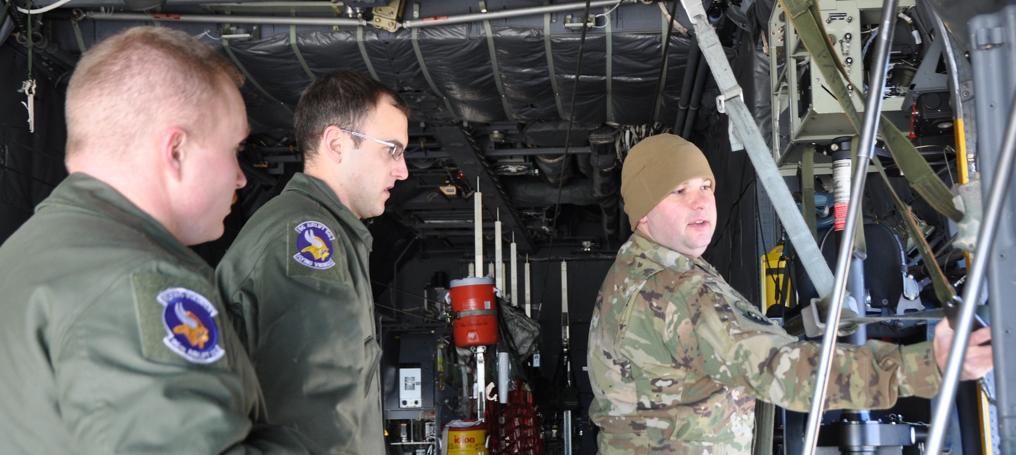 Tech. Sgt. Michael Hoffman, right, a C-130H loadmaster with the 700th Airlift Squadron, Dobbins, Air Reserve Base, Georgia, teaches Senior Airmen Erik Hannigan, left, and Kevin Pajor, C-130 loadmasters from the 96th Airlift Squadron, Minneapolis-St. Paul Air Reserve Station, Minnesota, about the towed parachute retrieval system during the loadmaster refresher course, Nov. 18 at Peterson Air Force Base, Colorado. About 70 loadmasters attended the training hosted by the 302nd Airlift Wing. (U.S. Air Force photo/Daniel Butterfield)