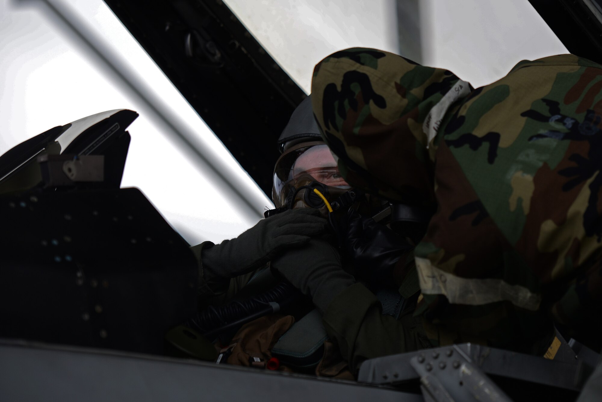U.S. Air Force 1st Lieutenant Robert Grochalski, 79th Fighter Squadron pilot, left, and Senior Airman Delvion Wilborne, 20th Aircraft Maintenance Squadron, 79th Aircraft Maintenance Unit tactical aircraft maintainer, work together to ensure Grochalski’s mask is secure before exiting the aircraft during an exercise at Shaw Air Force Base, S.C., Dec. 7, 2017.